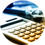 Calculator with many buttons, a pen, and paper in the background, all in a blurred, office setting.