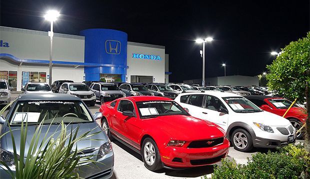 A lot of cars are parked in front of a honda dealership