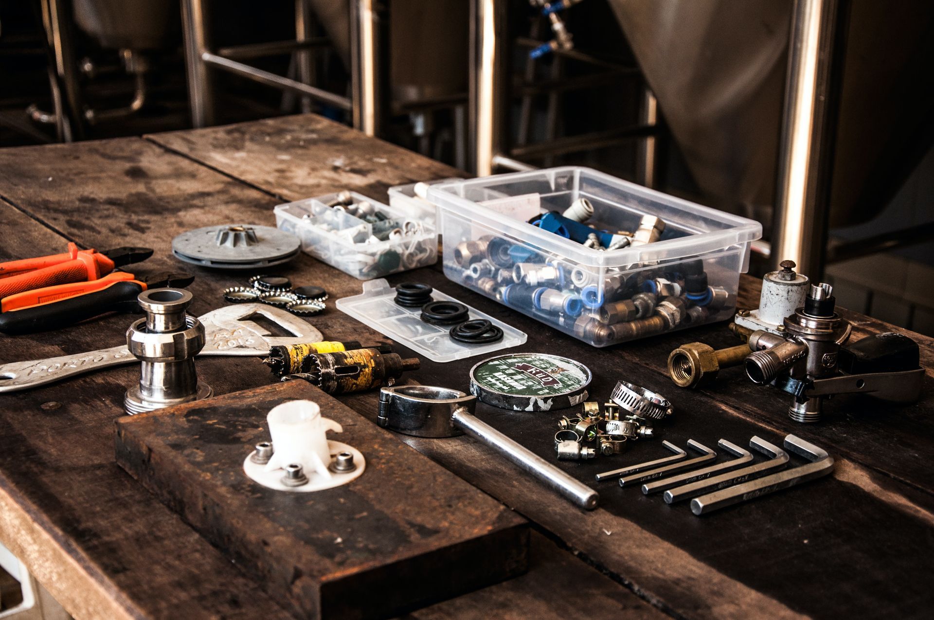 Tools and parts for industrial equipment assembly on a wooden table.