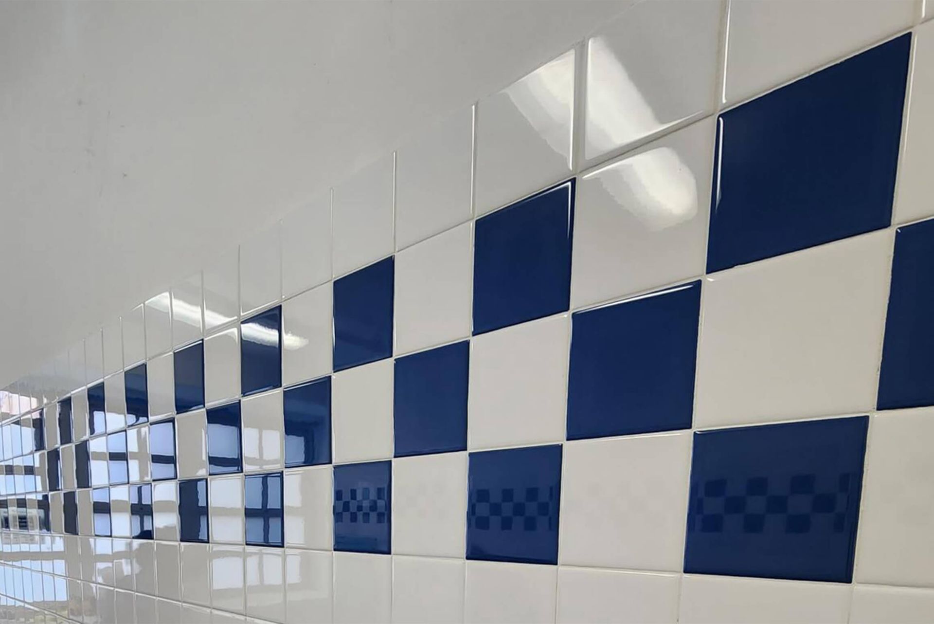 Blue and white checkered tiled wall, with a white ceiling above.