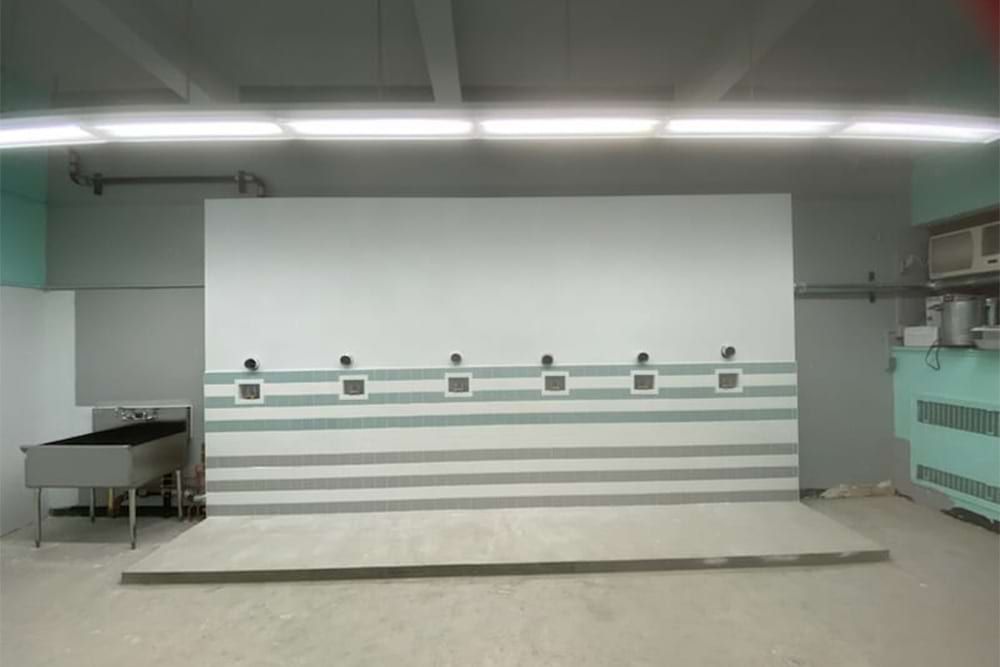 Indoor shooting range with white and gray walls, targets, and lighting.