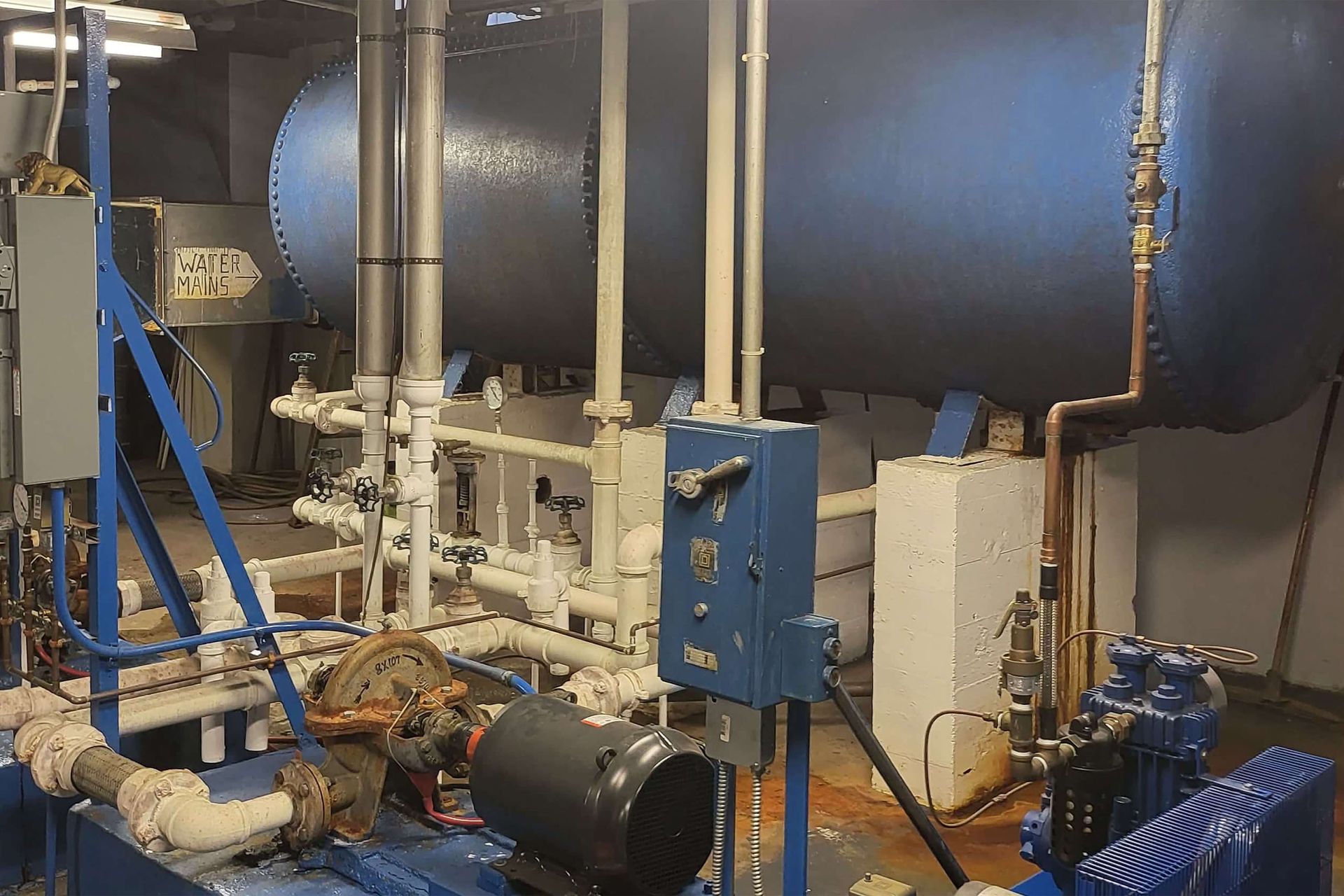 Industrial equipment: blue tank, pipes, valves, and electrical components.