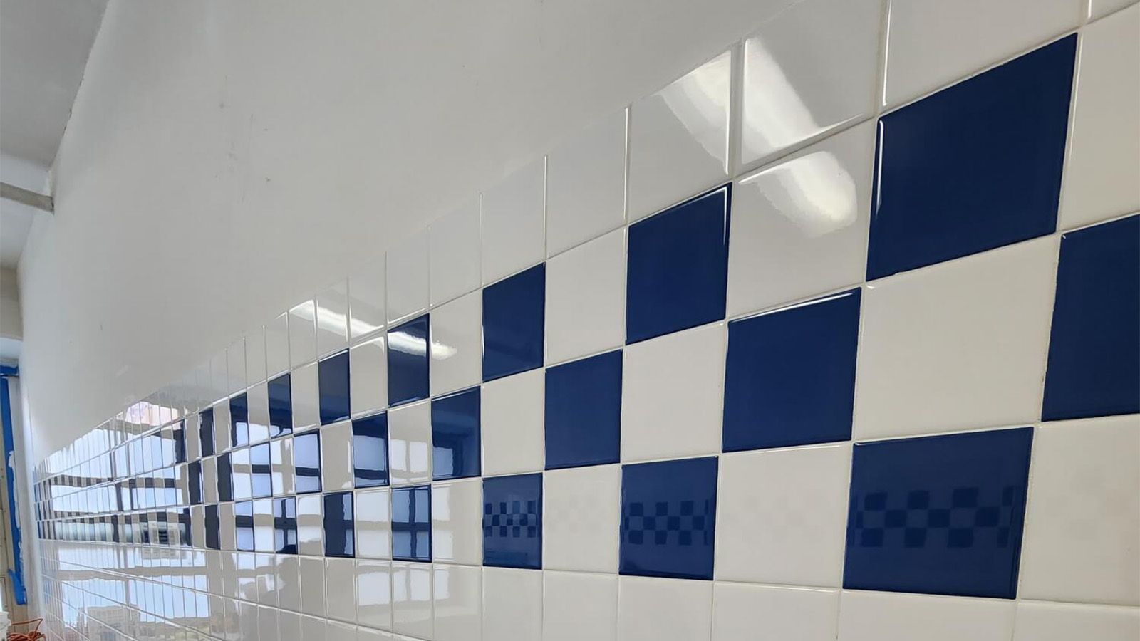 Blue and white checkered tile wall with a white ceiling.
