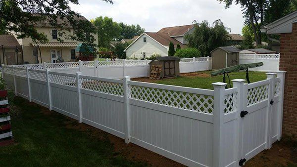 White vinyl privacy fence enclosing a green yard in a suburban neighborhood