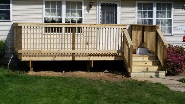 Back porch with wooden deck, steps, railing, and a ramp beside a house