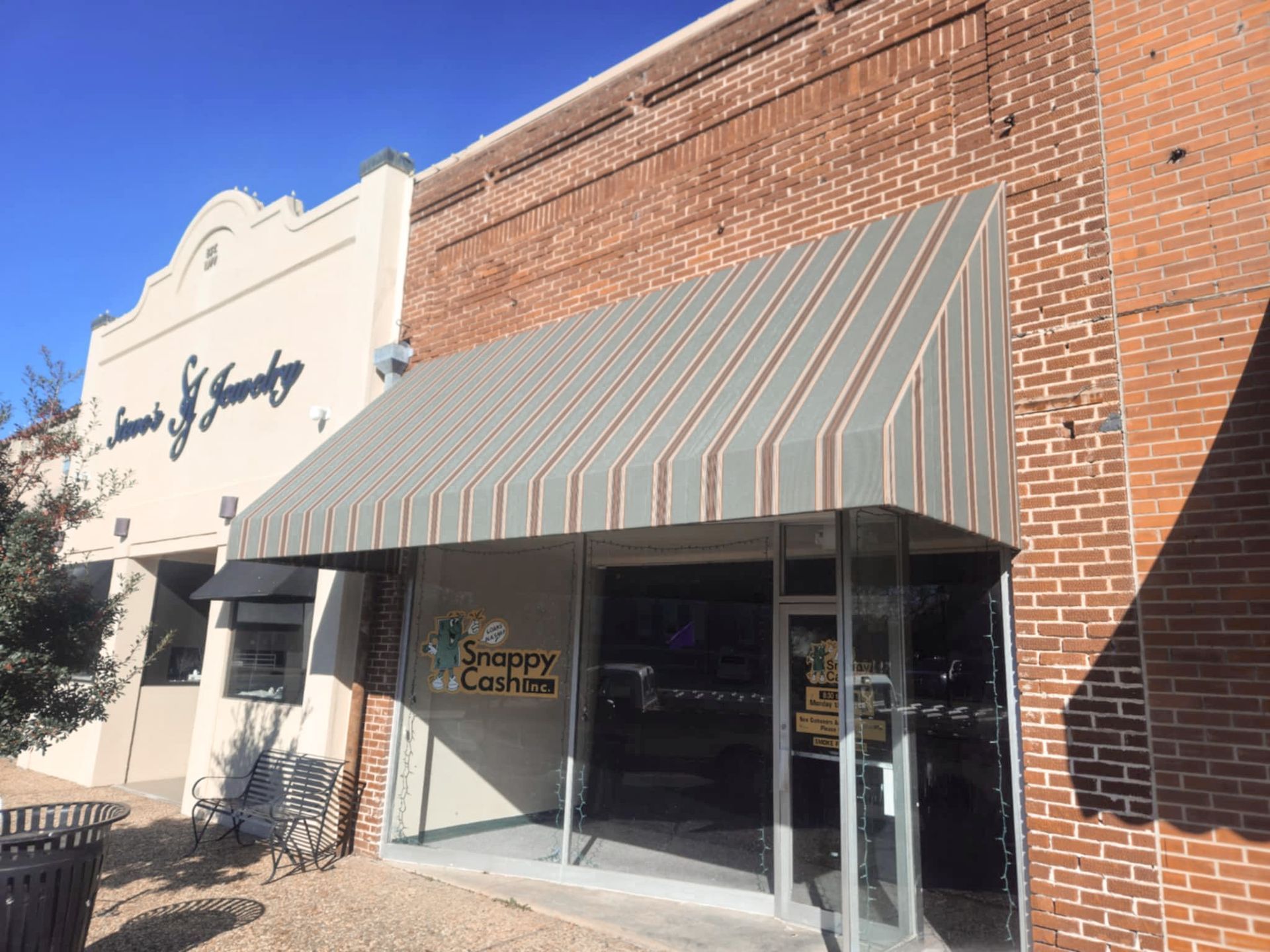 Exterior view of a storefront with striped awning, 