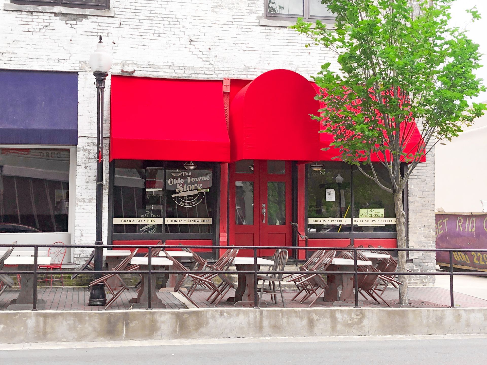 Restaurant with red awning and outdoor seating.
