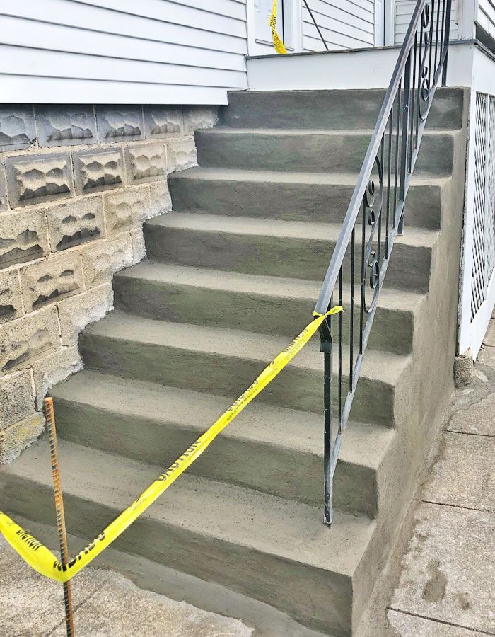 Blocked concrete stairs with yellow caution tape beside a house exterior