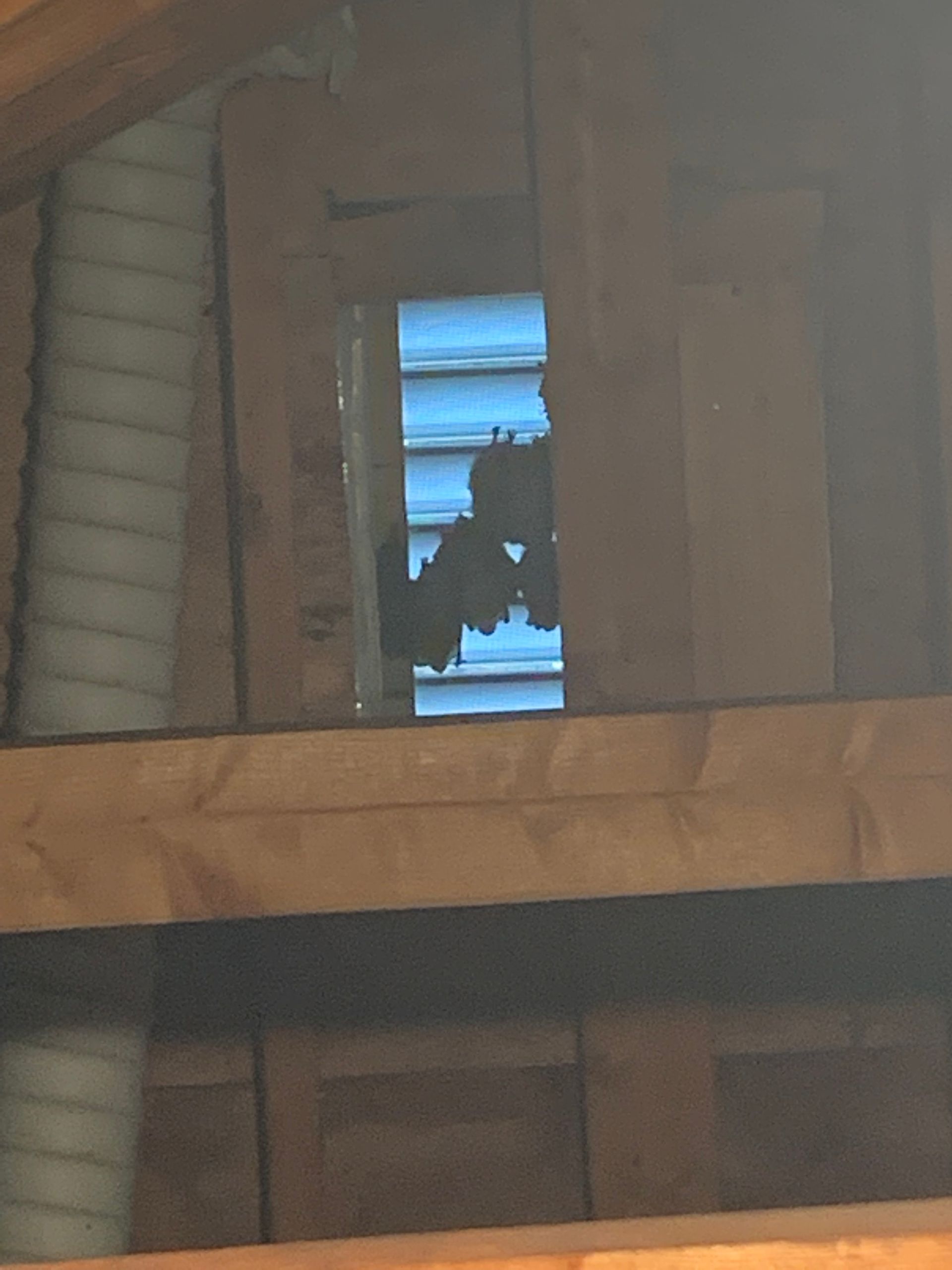Person silhouetted in a window of an unfinished wooden interior
