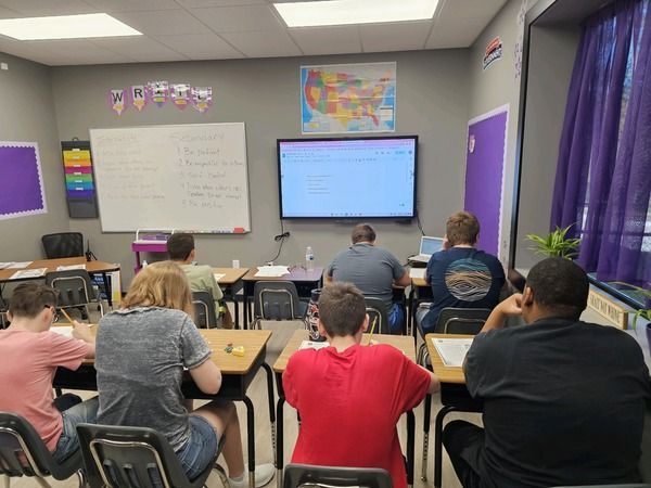 A group of students are sitting at desks in a classroom.