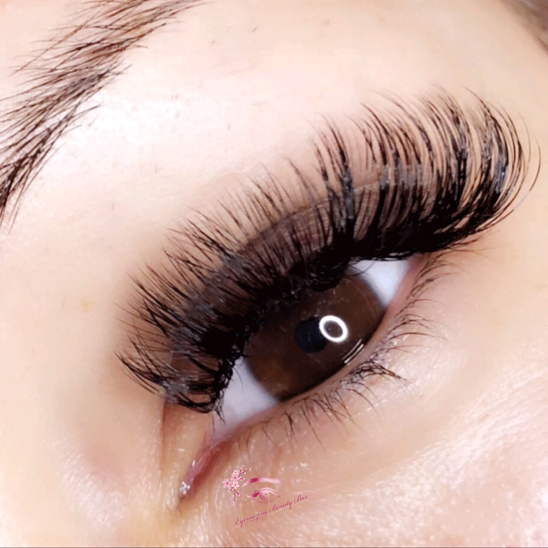 A close up of a woman 's eye with long eyelashes.