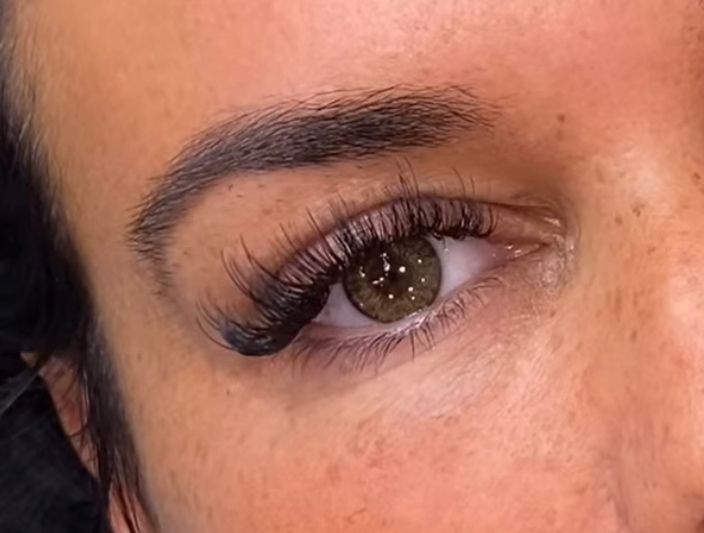 A close up of a woman 's eye with long eyelashes.