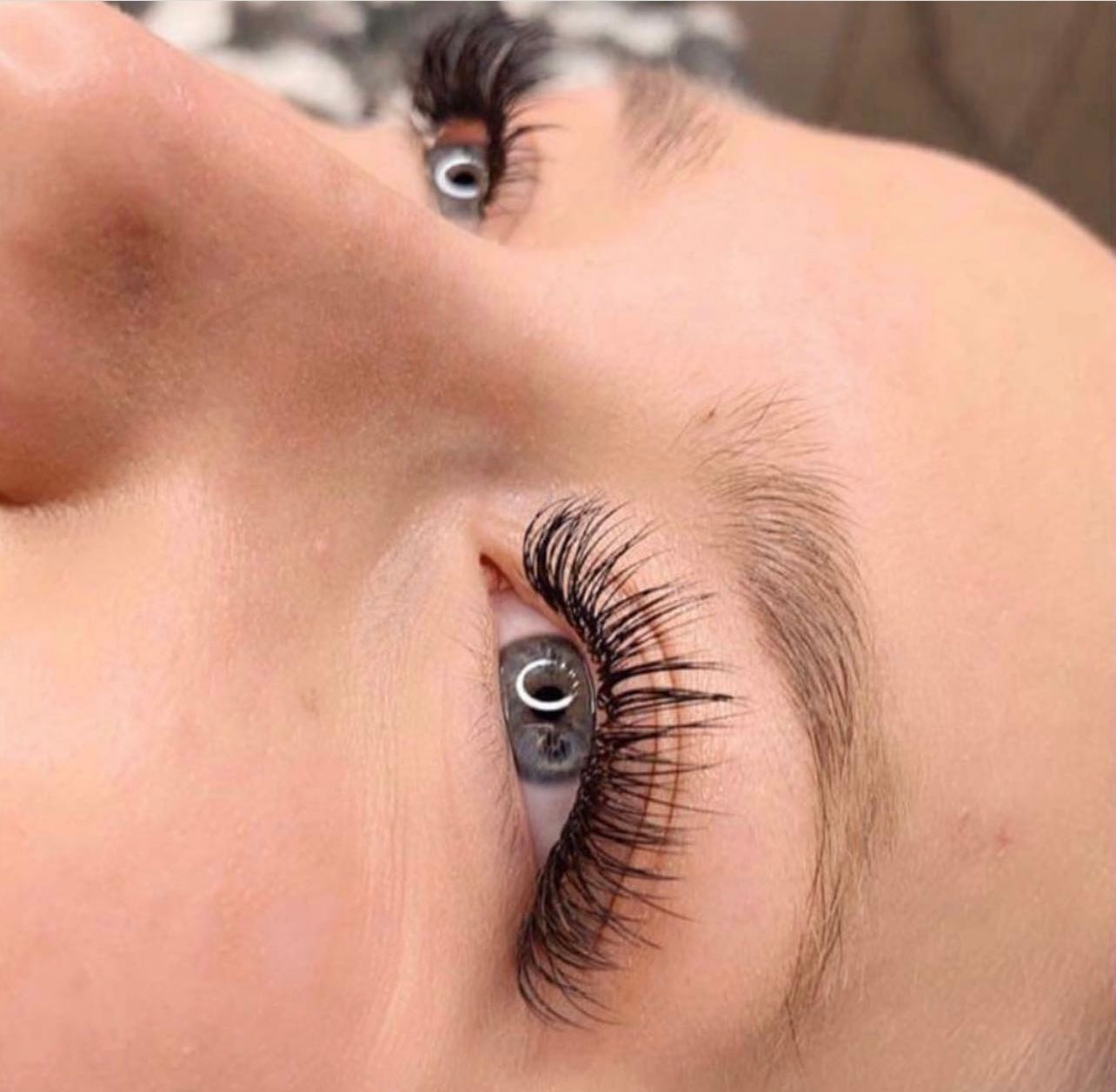 A close up of a woman 's eye with long eyelashes.