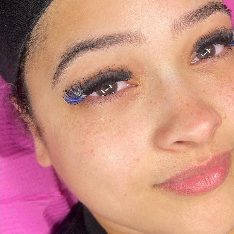 A close up of a woman 's face with long eyelashes.
