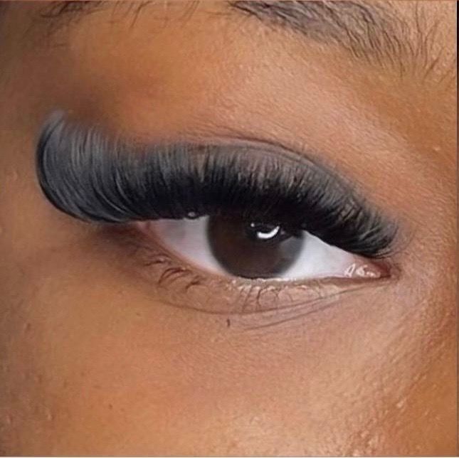 Close-up of a brown eye with long, curled black eyelash extensions