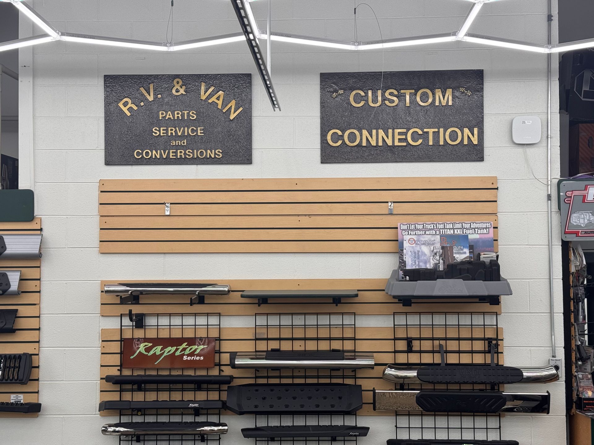 Store wall display of wooden slat panels and black shelving with “Custom Connection” signs