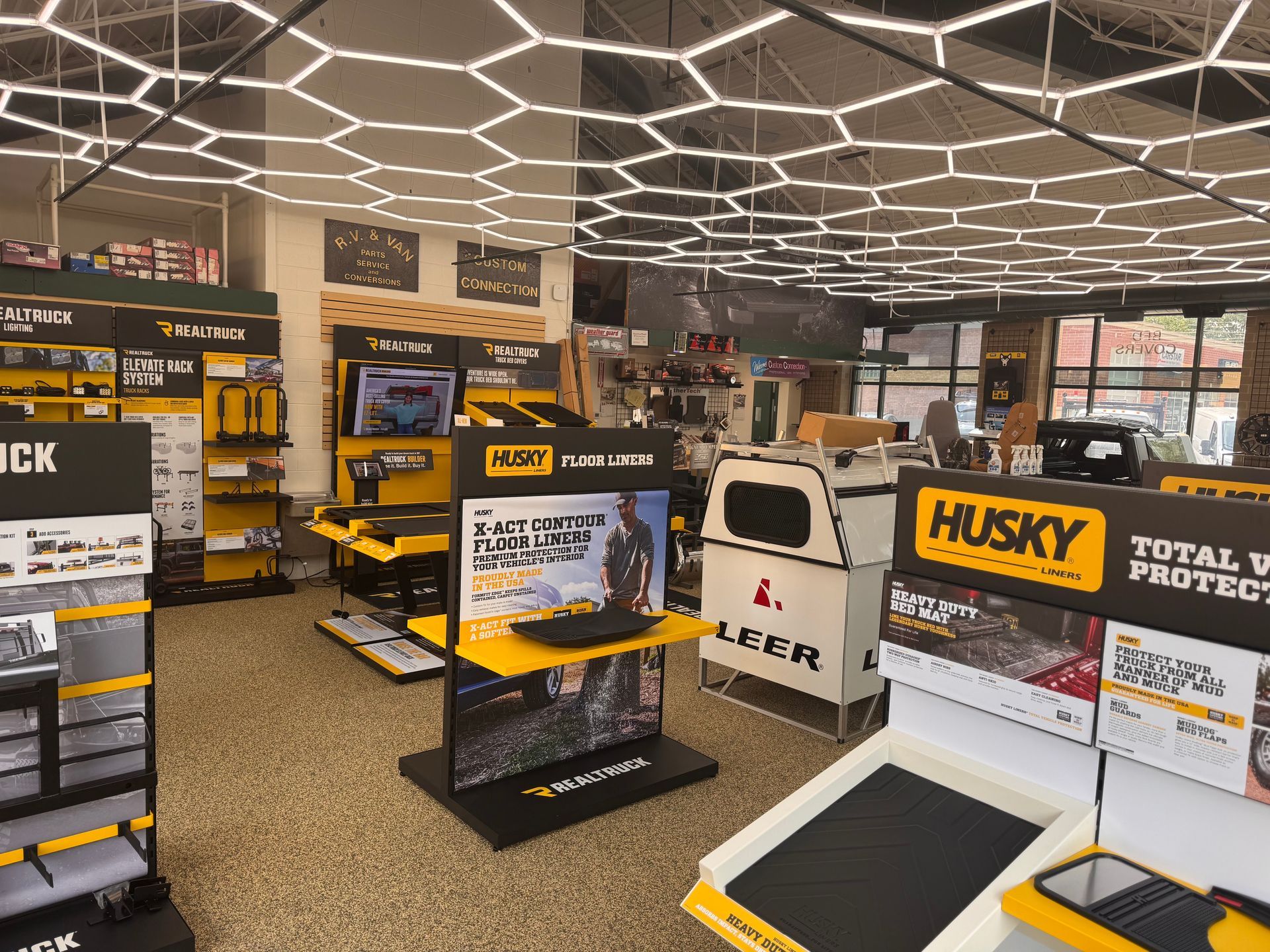 Appliance store display with Husky tool cabinets and yellow-black power tools under bright ceiling lights.