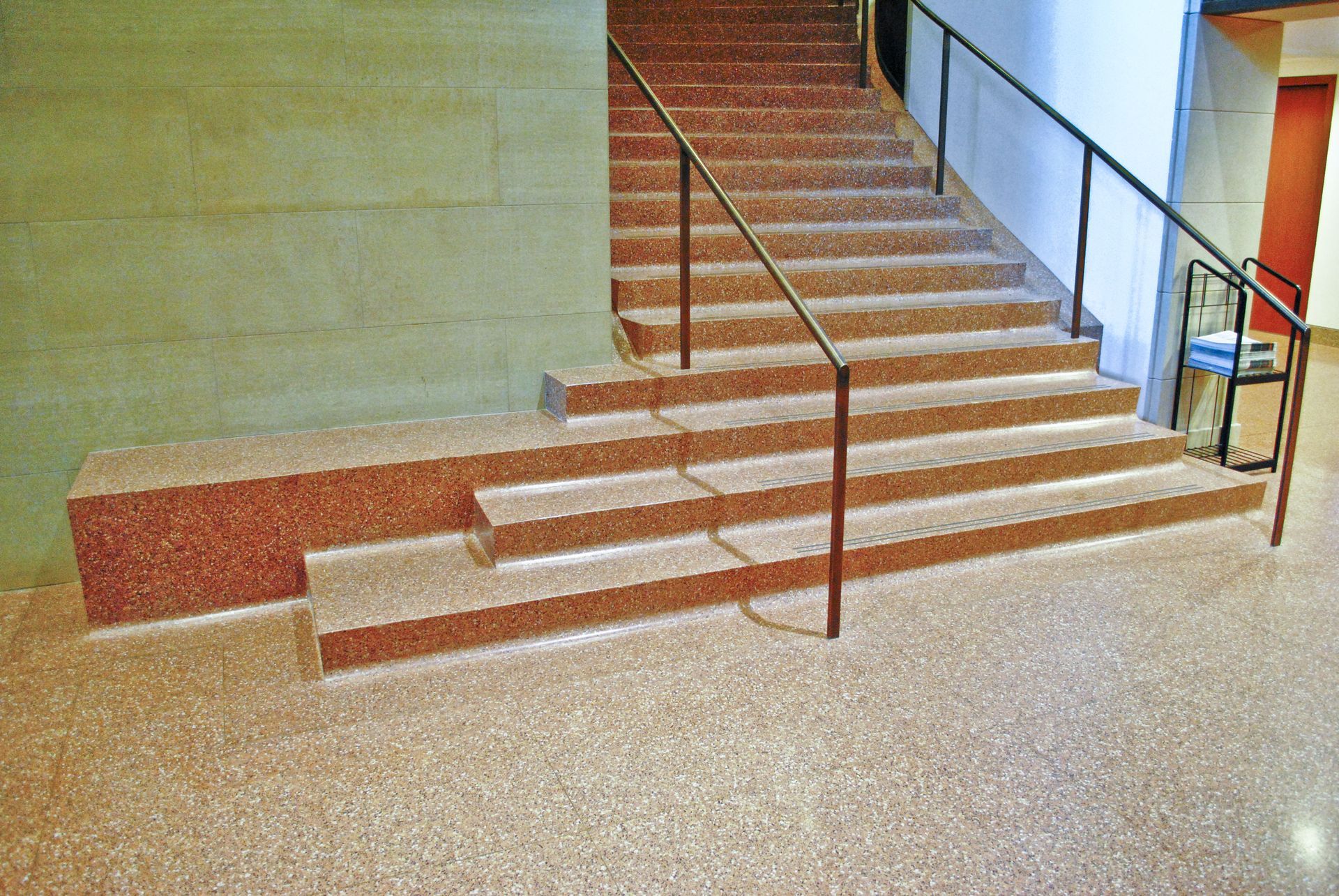 A set of stairs in a building with a metal railing
