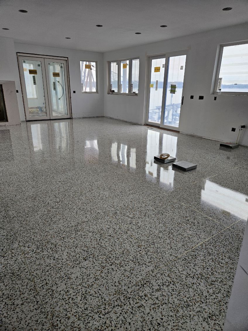 A large room with a marble floor and lots of windows.