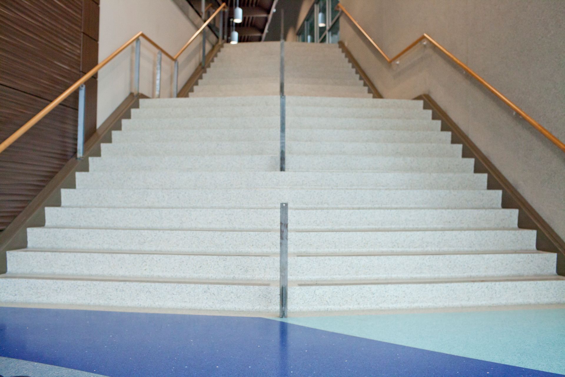 A set of stairs with a wooden railing in a building