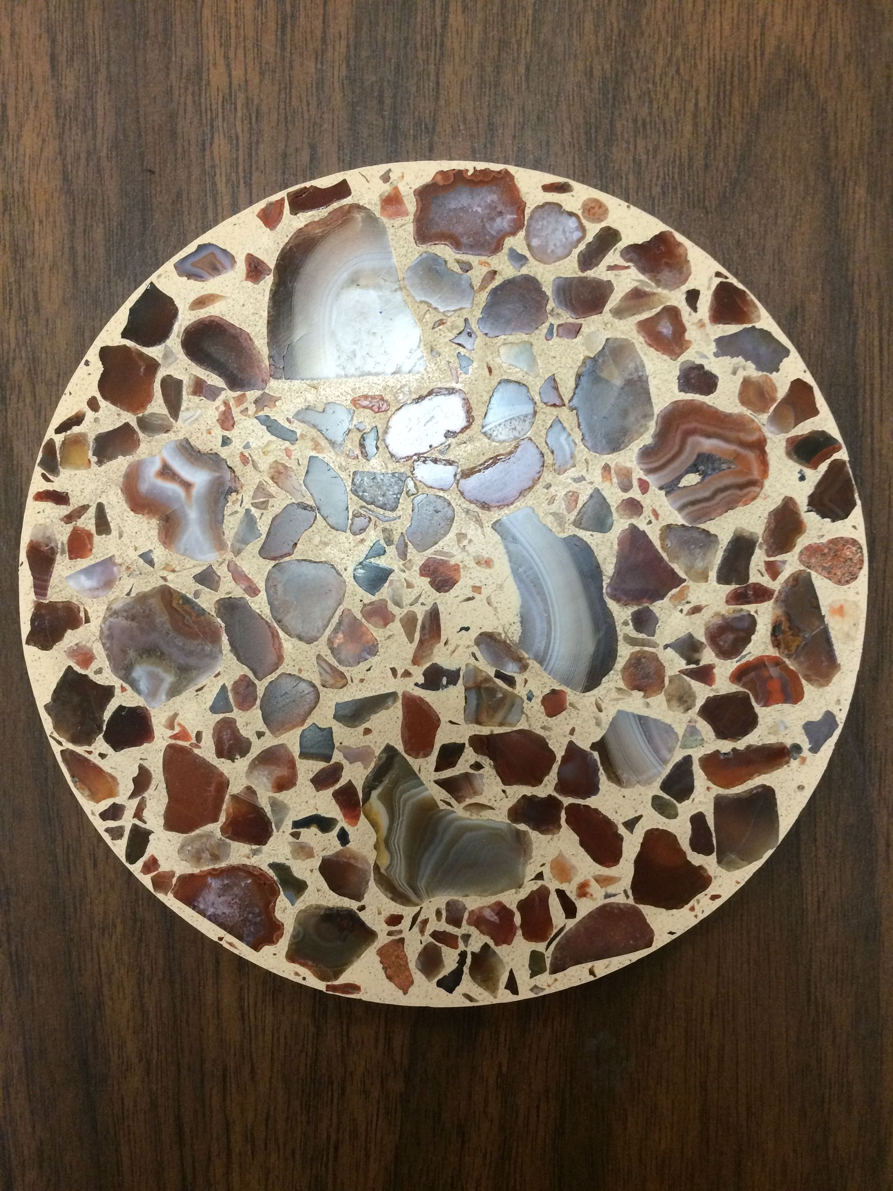 A plate with a pattern of rocks on it is sitting on a wooden table.