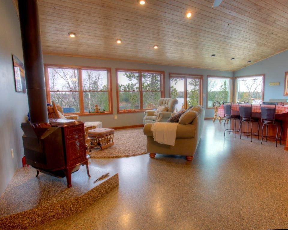A living room with a wood stove and lots of windows