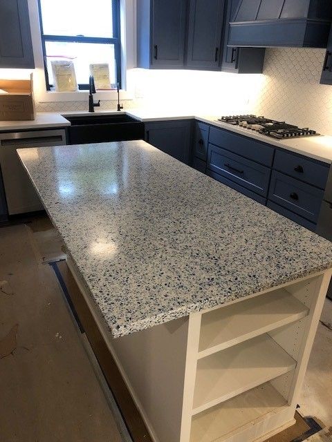 A kitchen with granite counter tops and blue cabinets