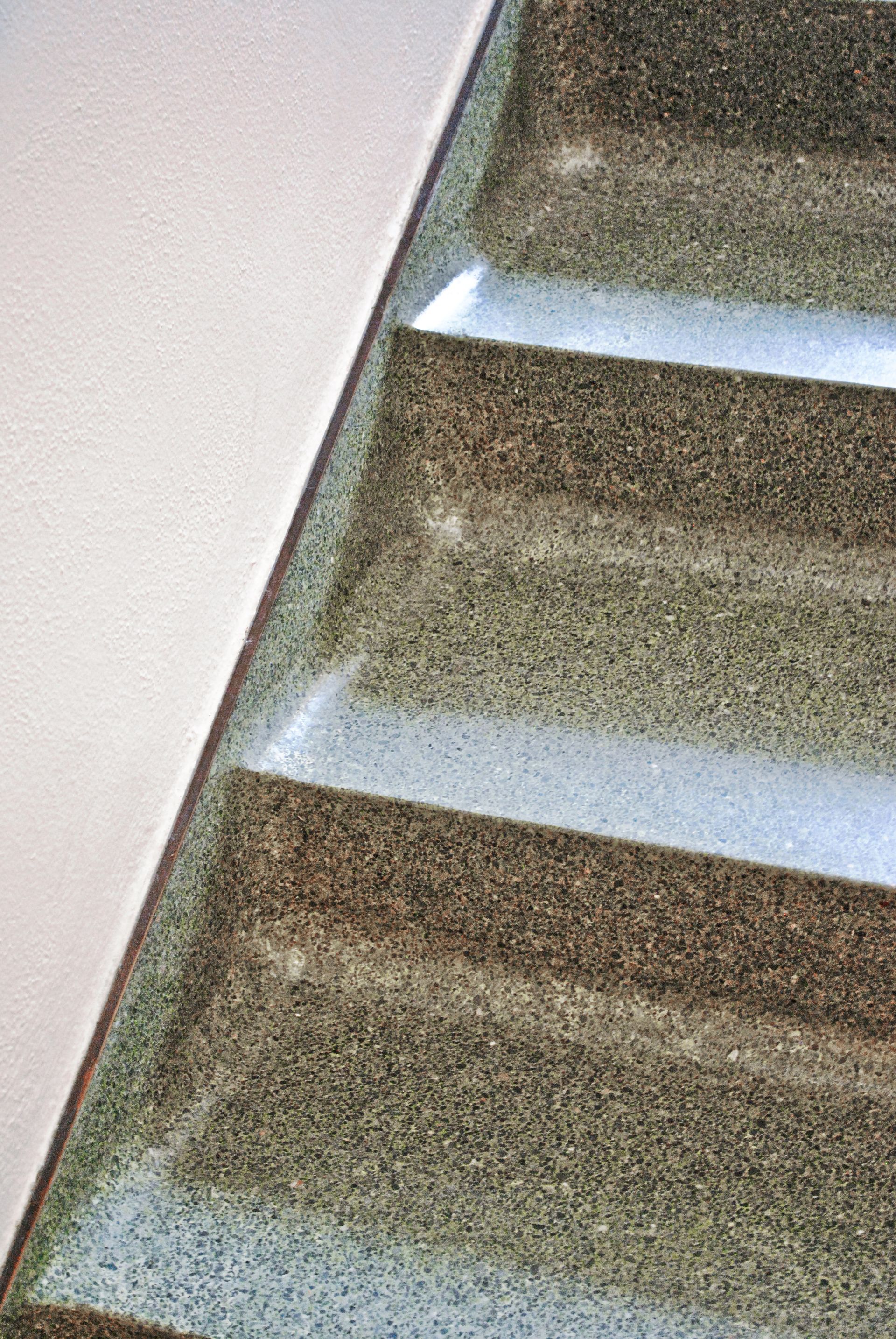 A close up of a set of stairs with a white railing.