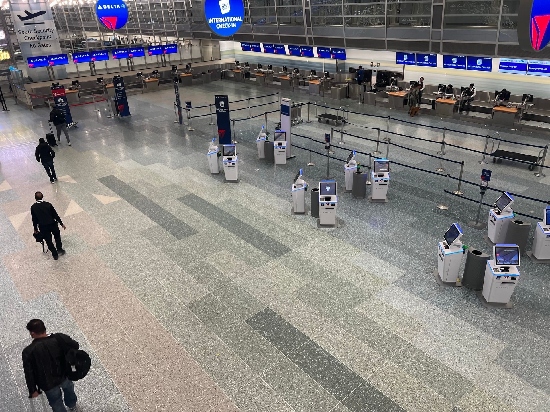 A group of people are walking through an airport terminal.