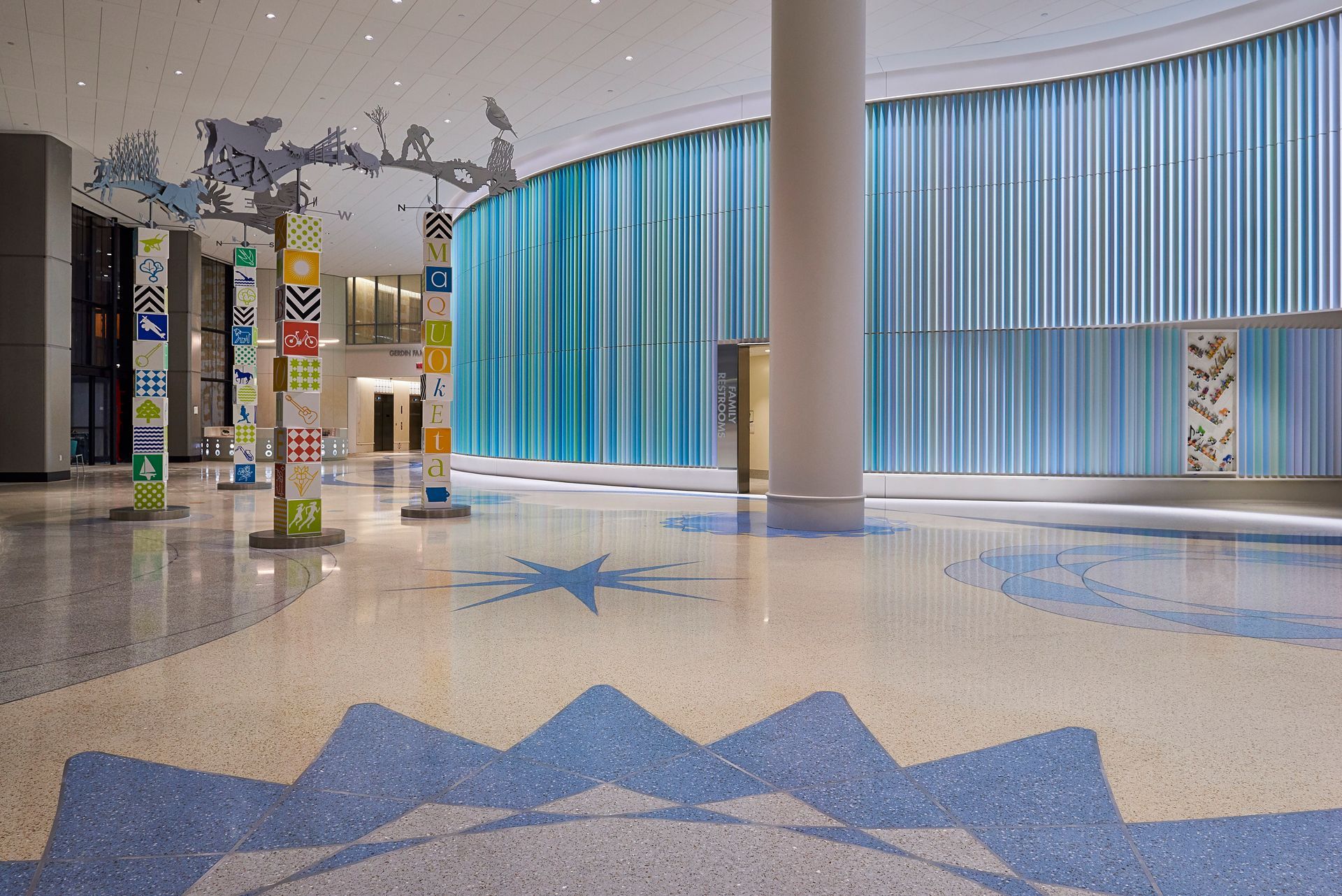 A large hallway with a mosaic floor and blue curtains