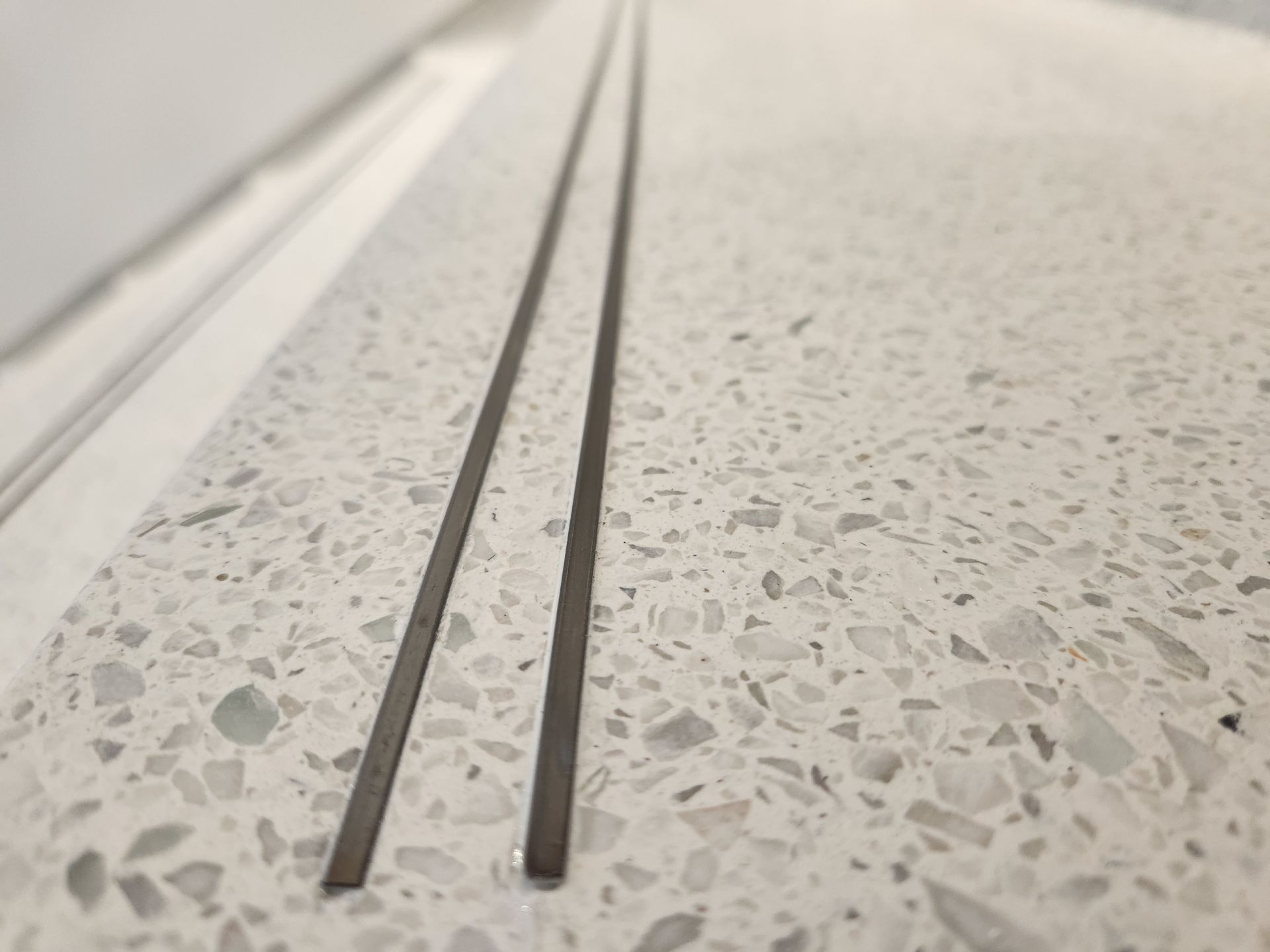 A close up of two metal rods on a white counter top.