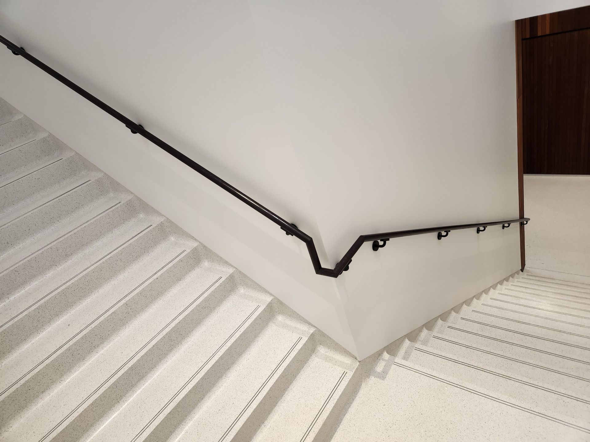 A staircase with a black railing and white steps