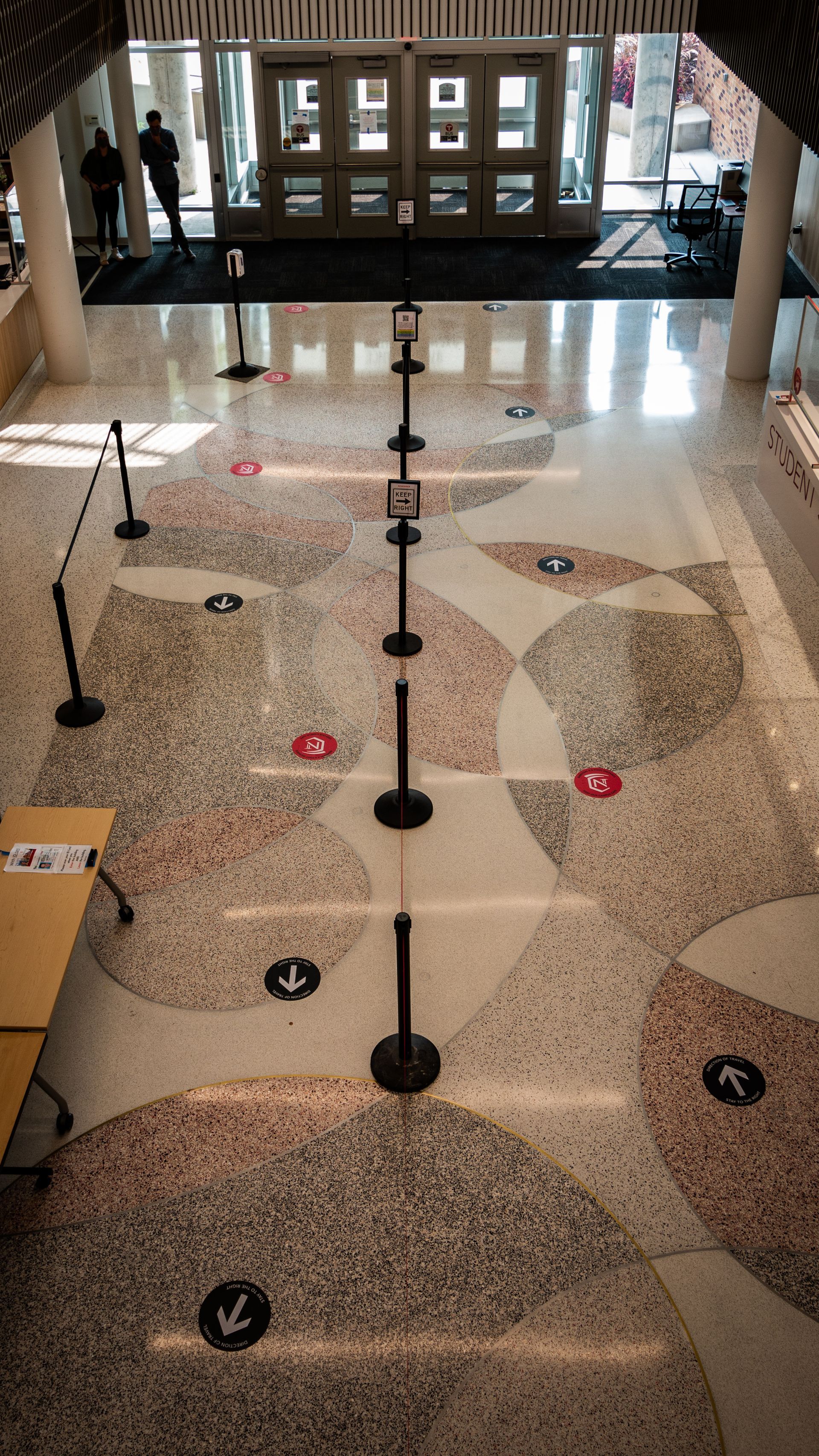 An aerial view of the lobby of a building with social distancing markers on the floor.