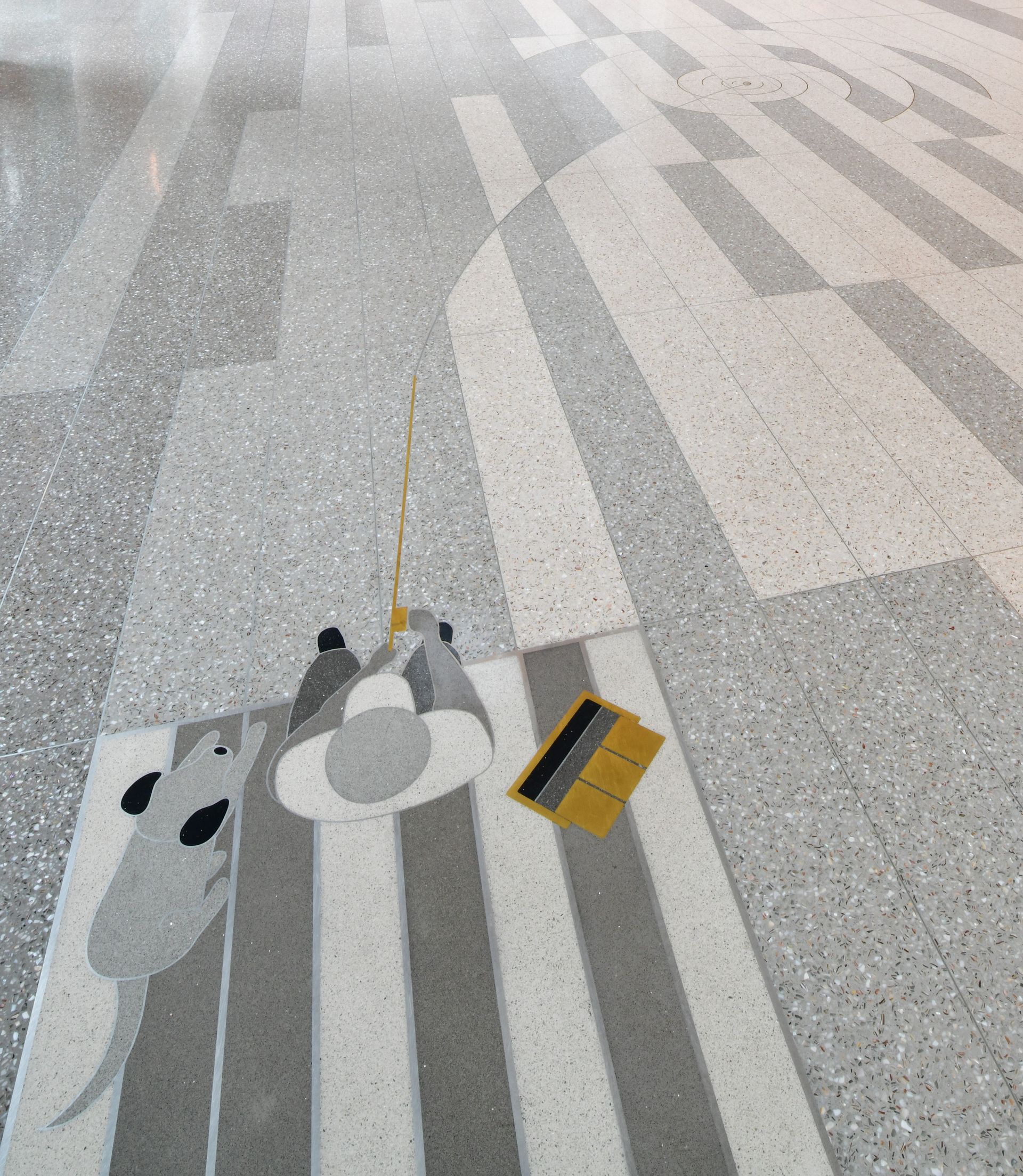 A gray and white striped floor with a yellow square in the middle