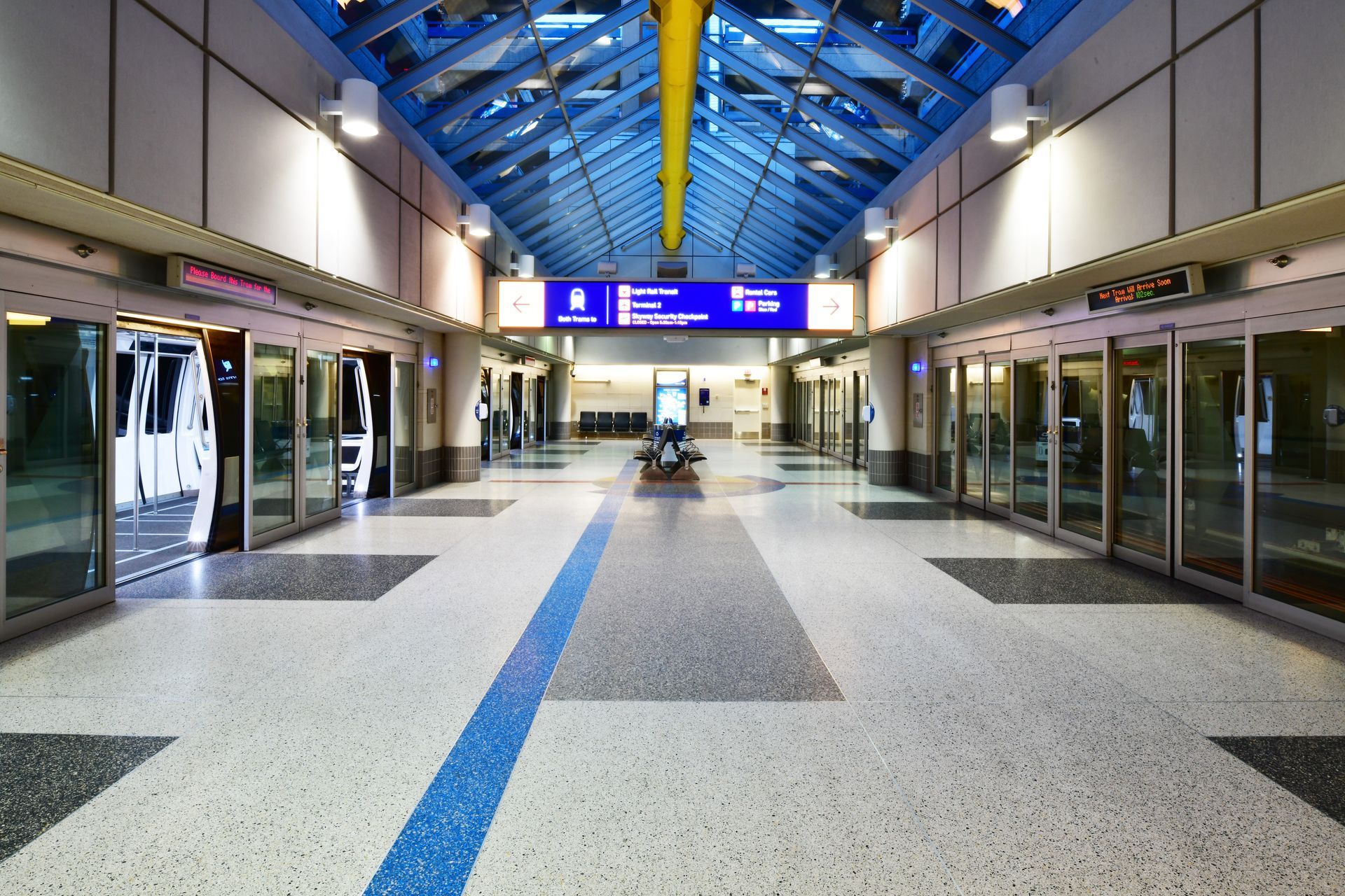 A train station with a blue ceiling and a sign that says emergency