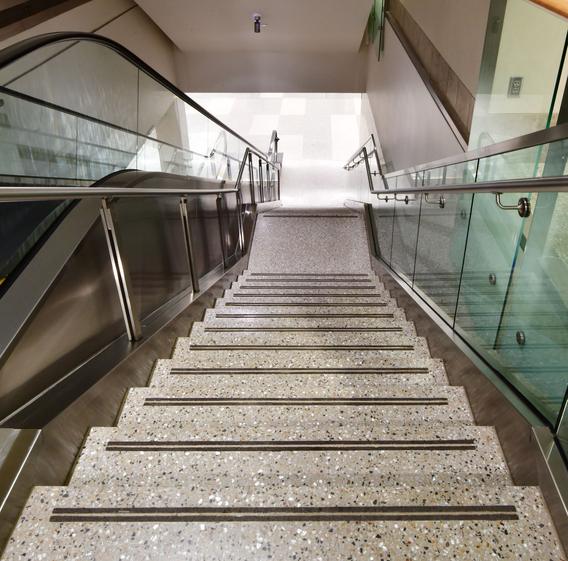 A set of stairs leading up to an escalator in a building