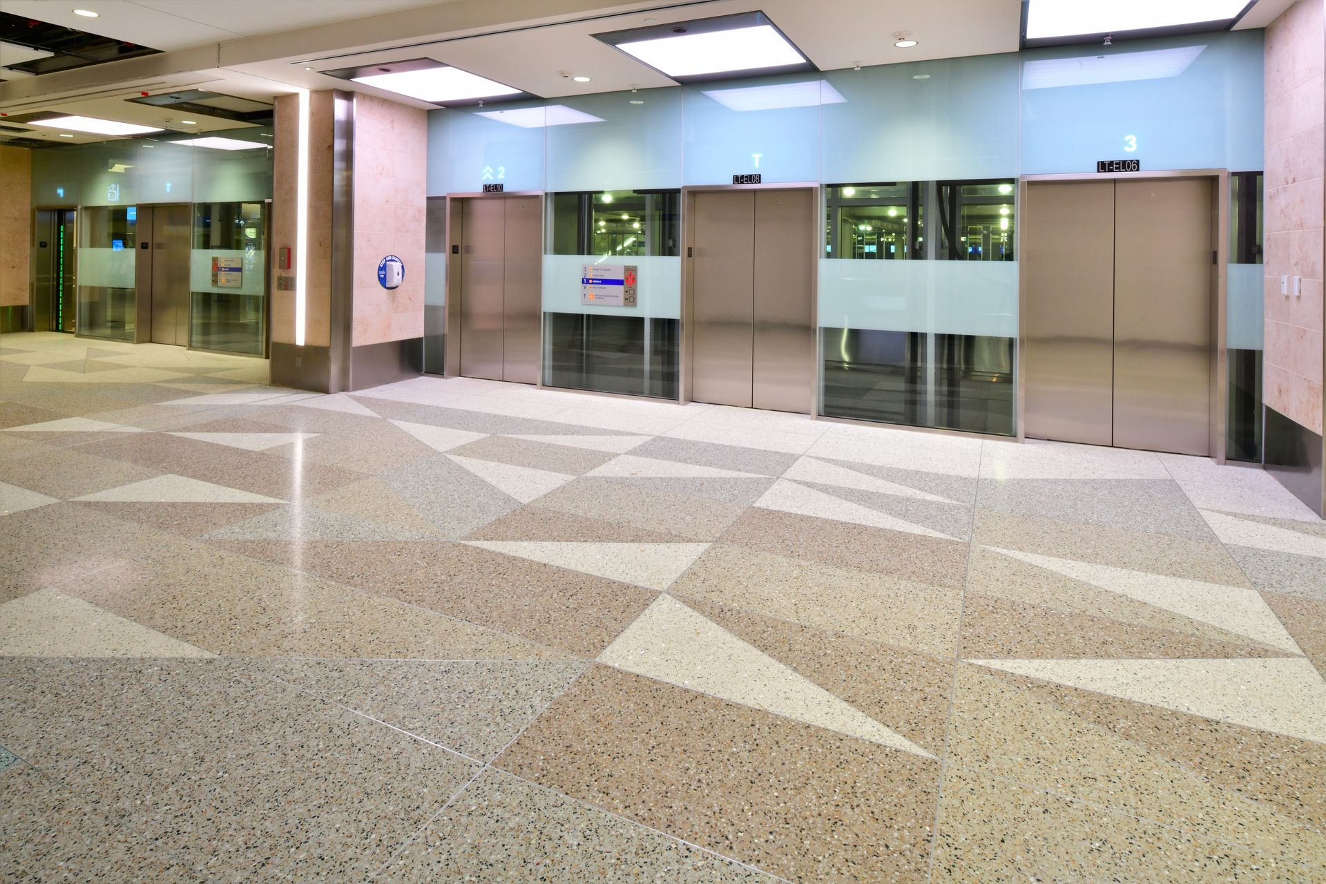 A row of elevators in a building with an arrow pointing to the right