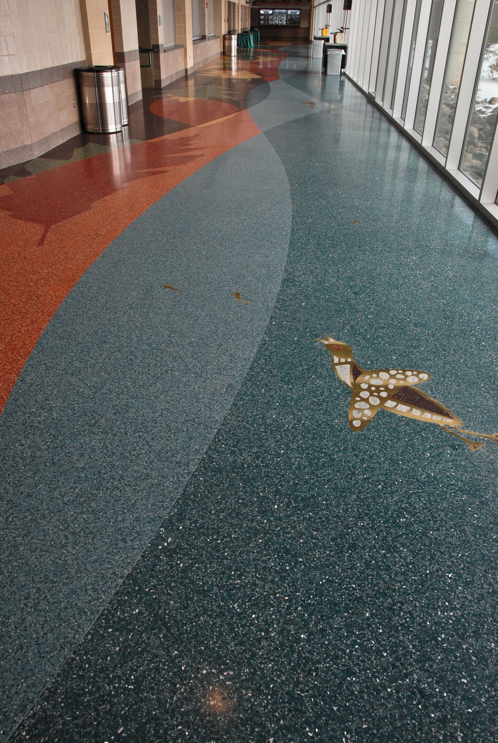 A hallway with a mosaic of a bird on the floor.