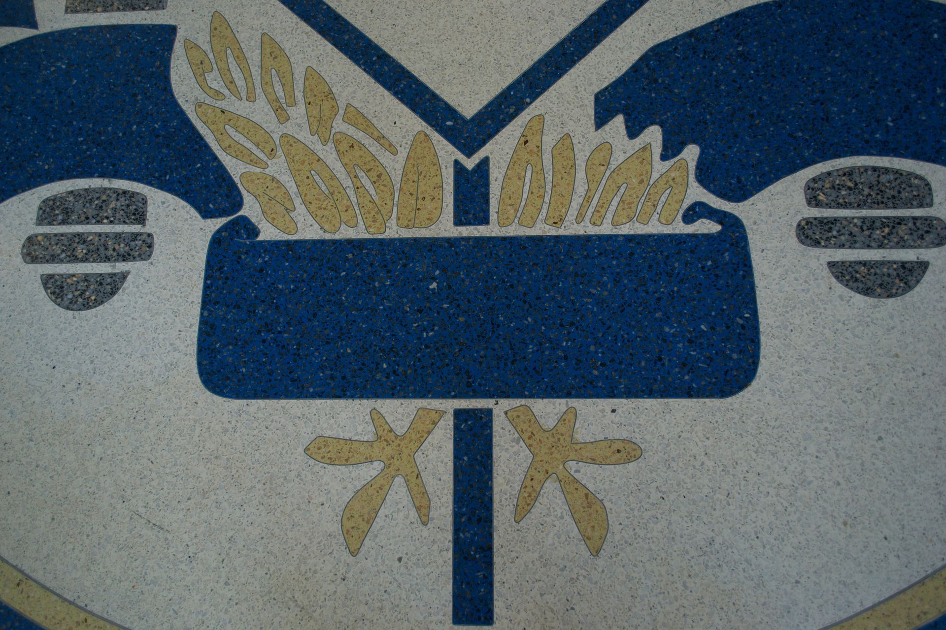 A blue and white emblem with a cross and wheat on it