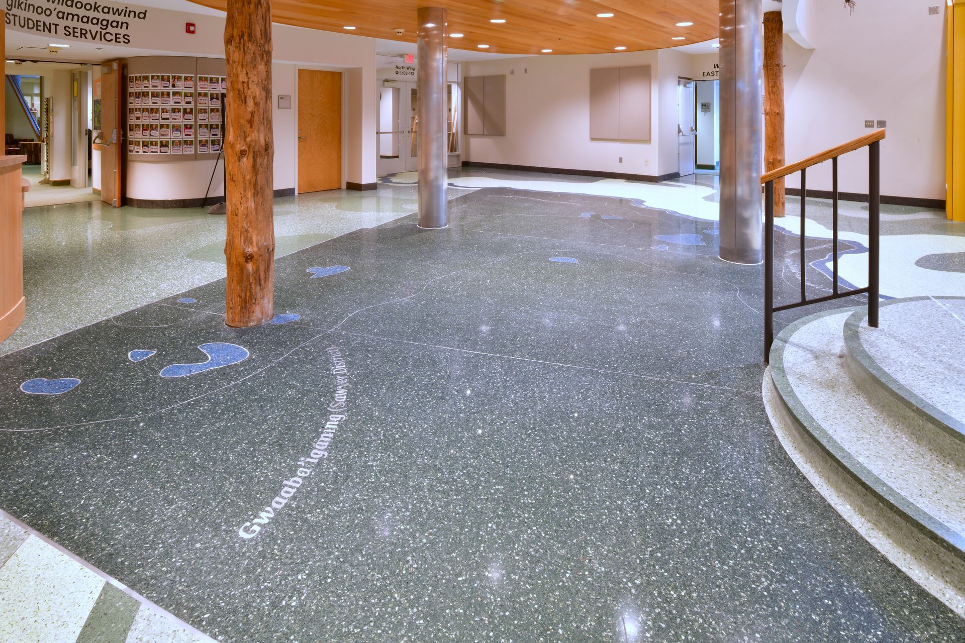 A large room with a staircase and a sign that says ' welcome ' on it