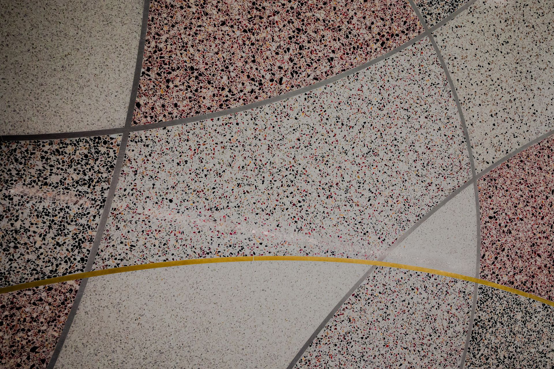 A close up of a tiled floor with a yellow line in the middle.