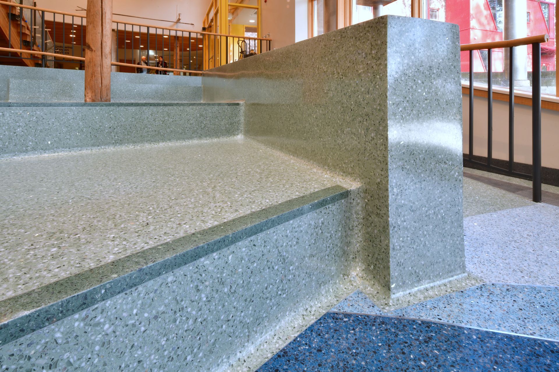 A set of stairs with a blue carpet on the floor