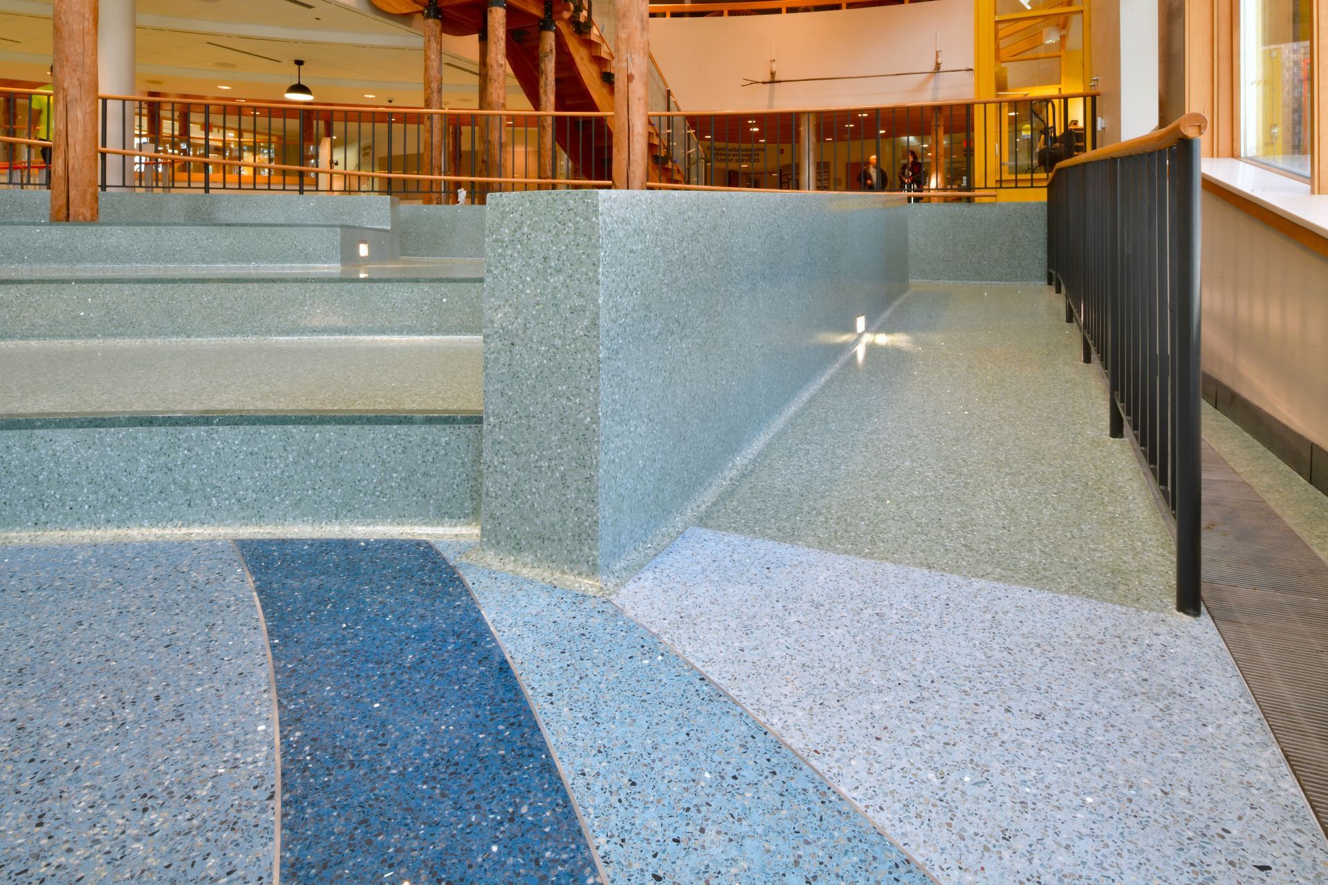 A staircase in a building with a blue and white tile floor