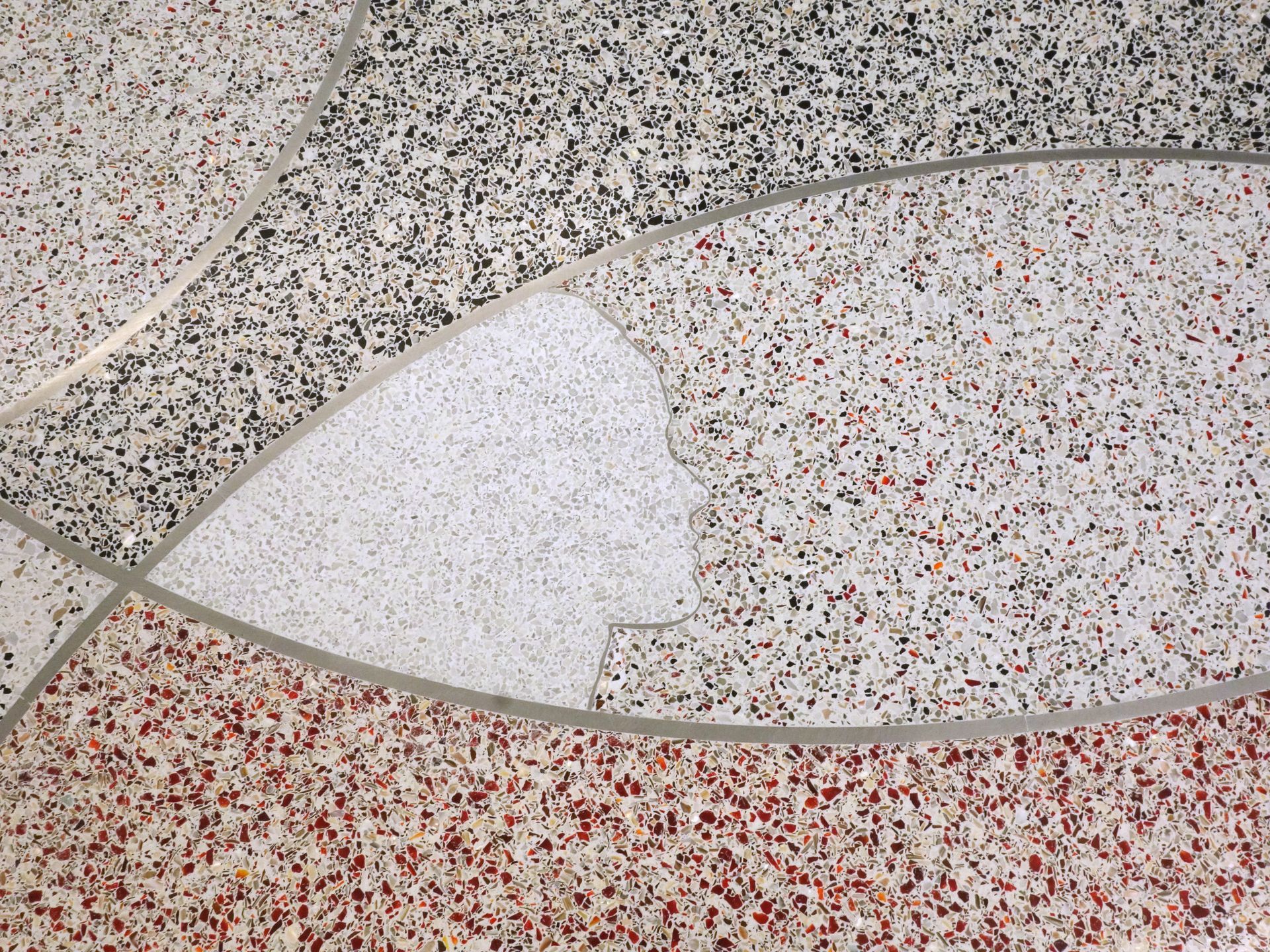 A close up of a tiled floor with a red , white and black pattern.