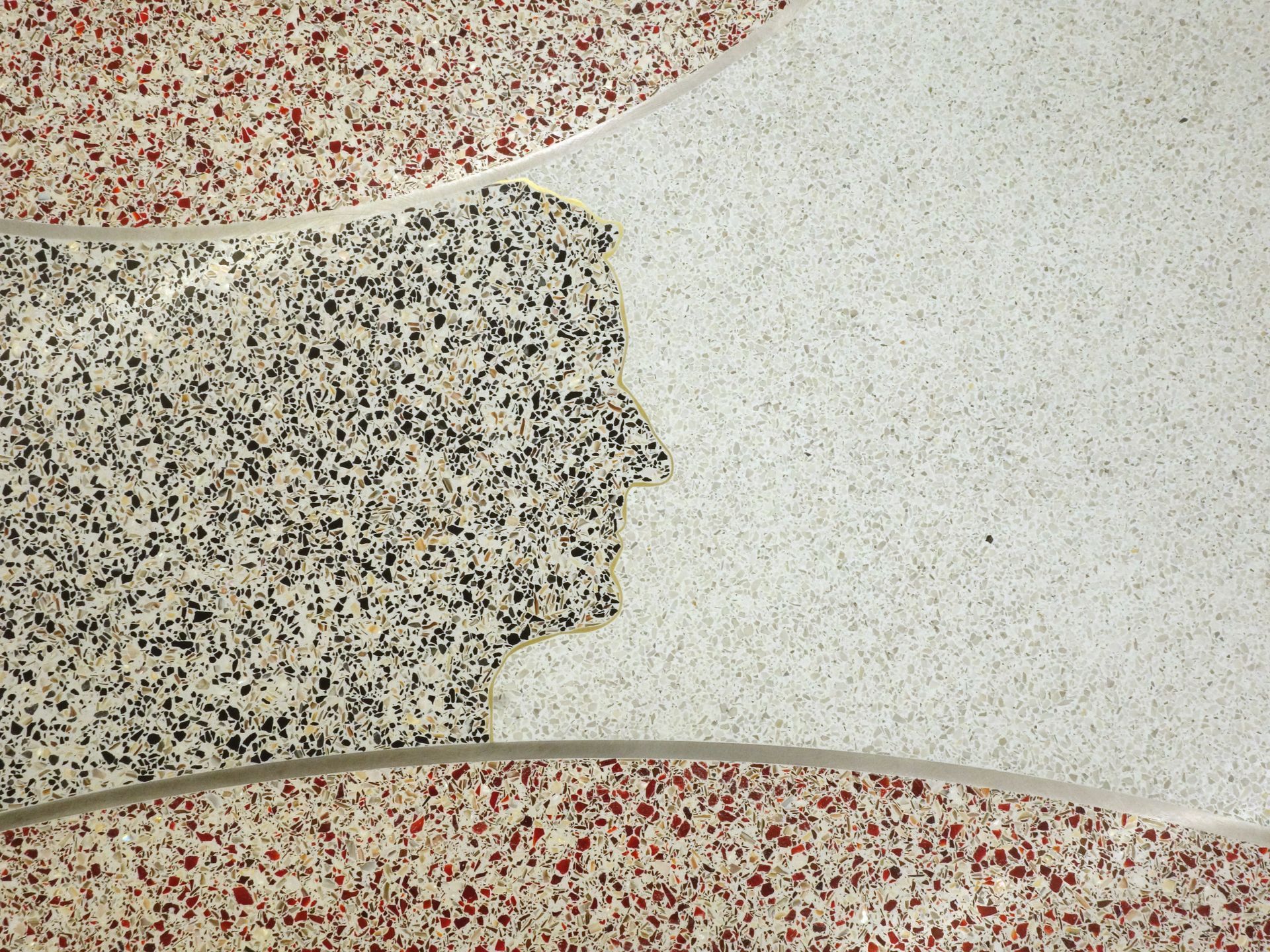 A silhouette of a man 's head is on a marble surface