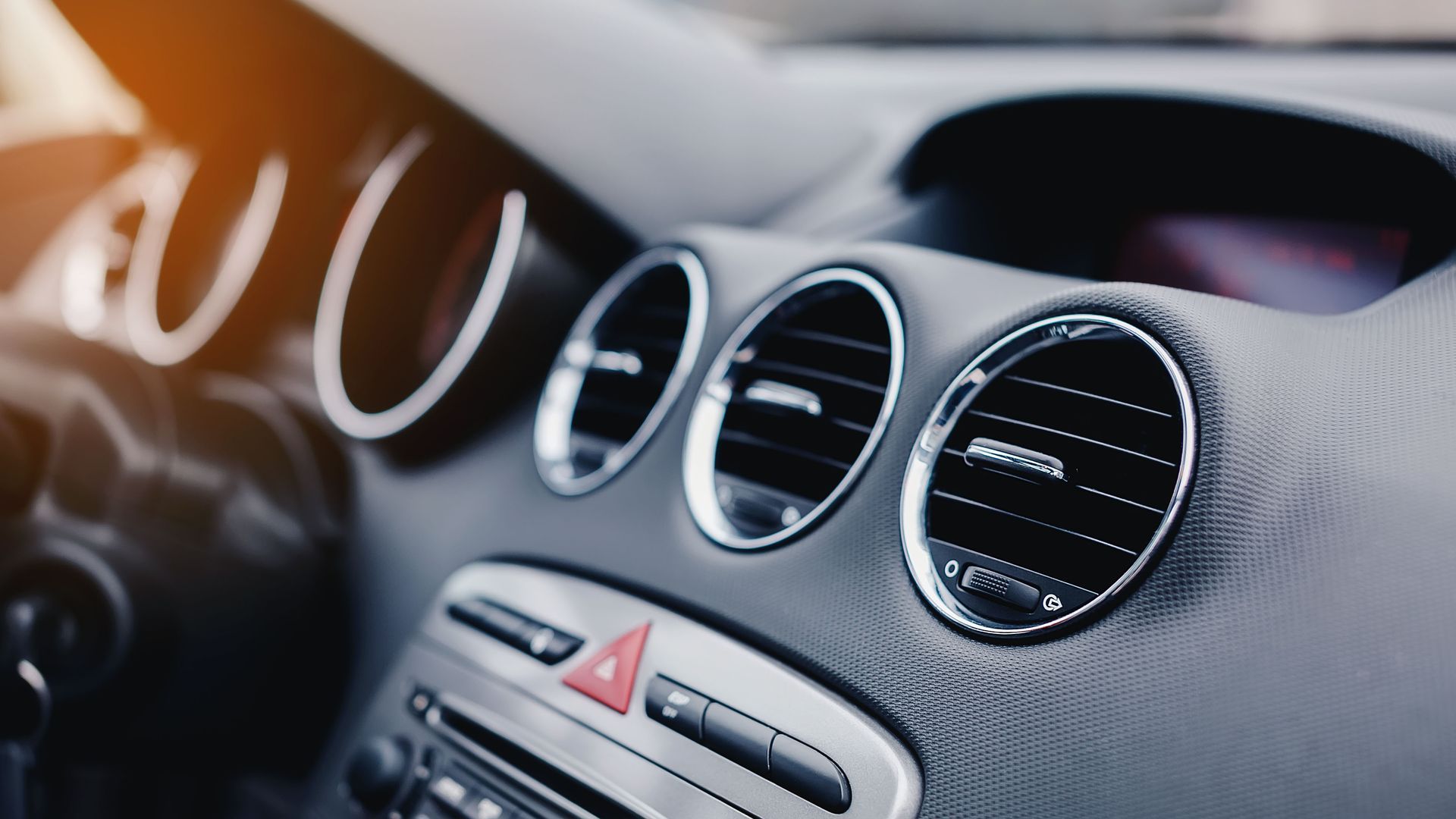 A close up of the air vents on the dashboard of a car.