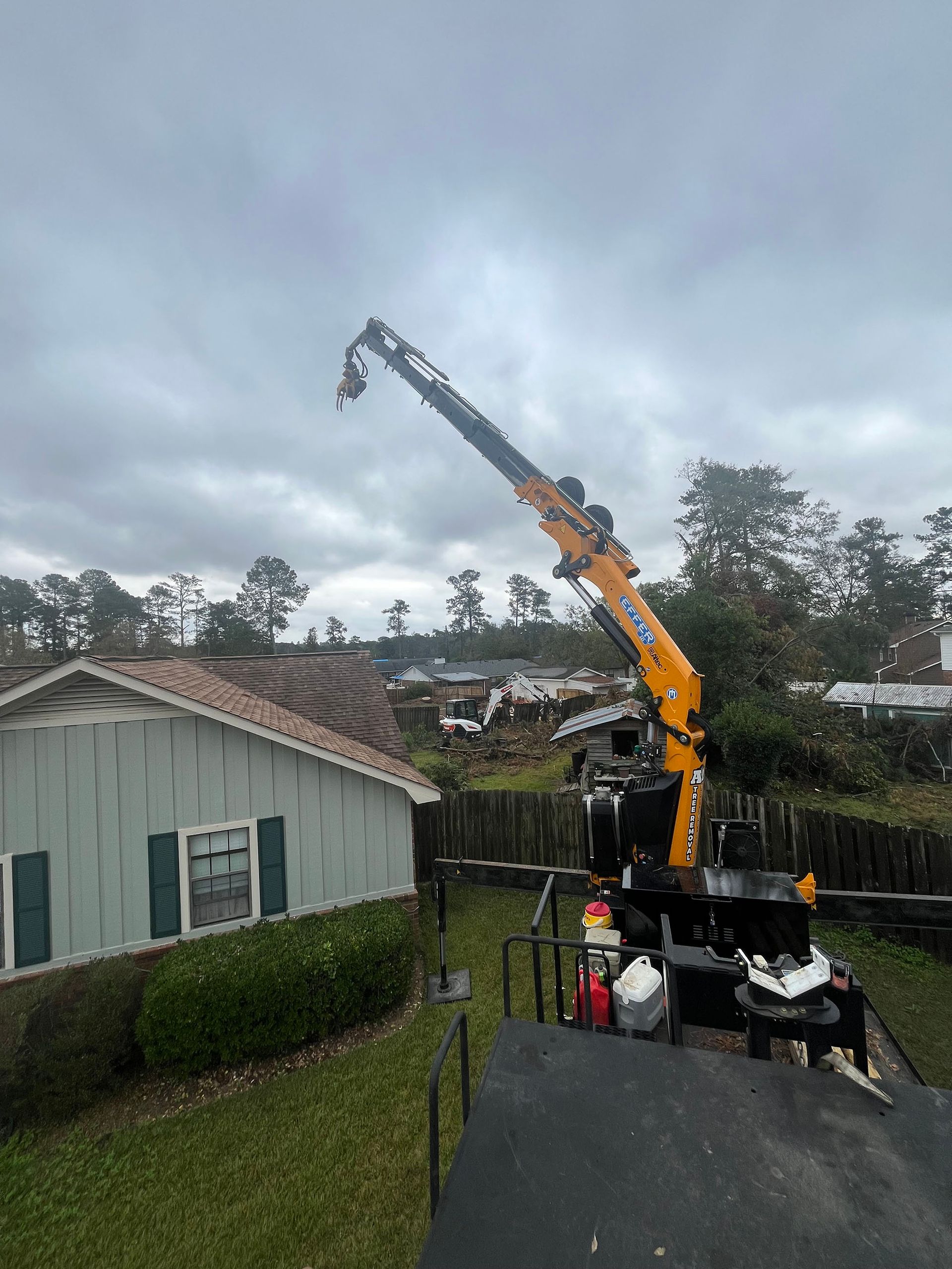A crane is sitting on top of a truck in front of a house.