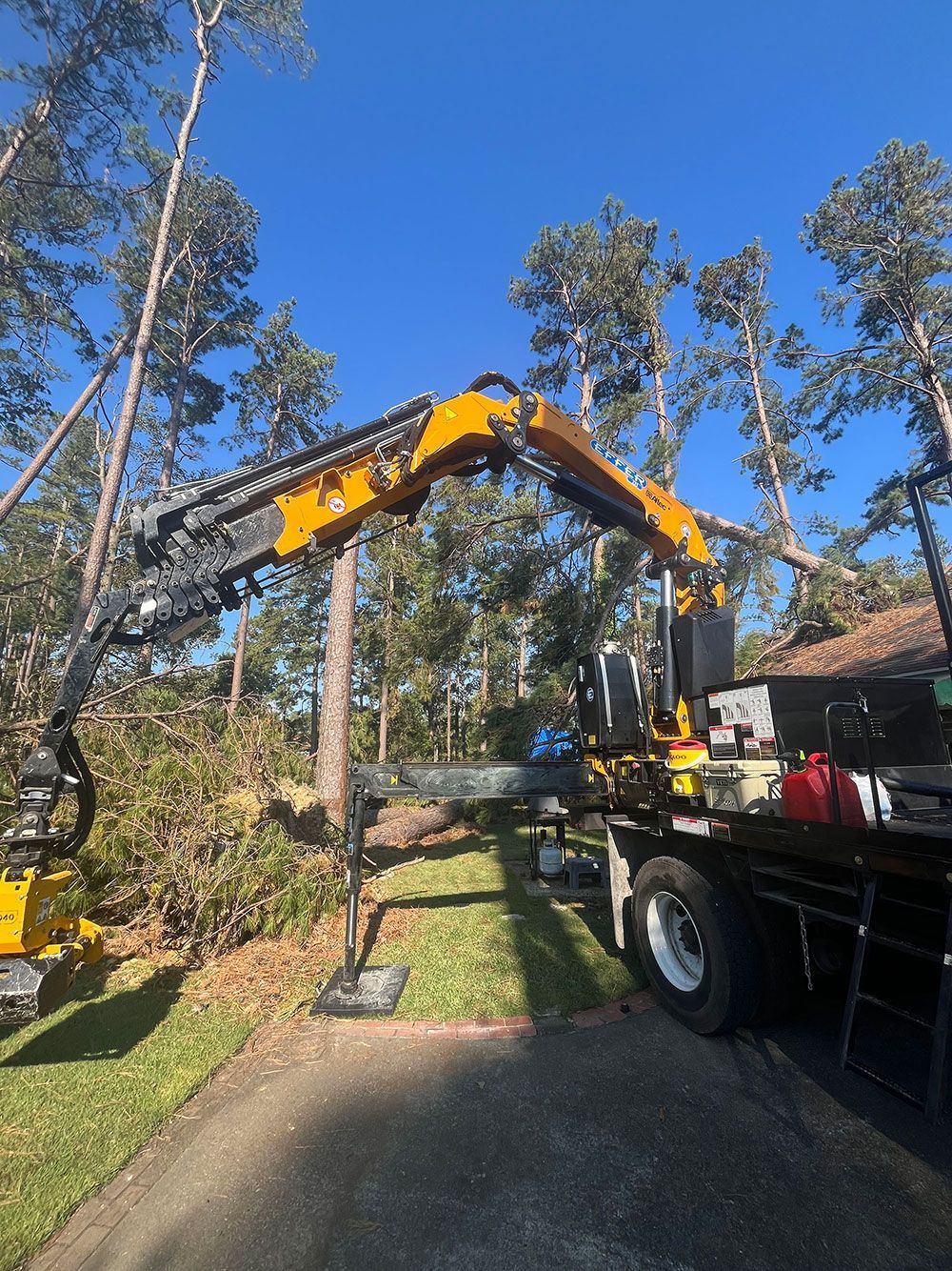 A large yellow crane is sitting on top of a truck.