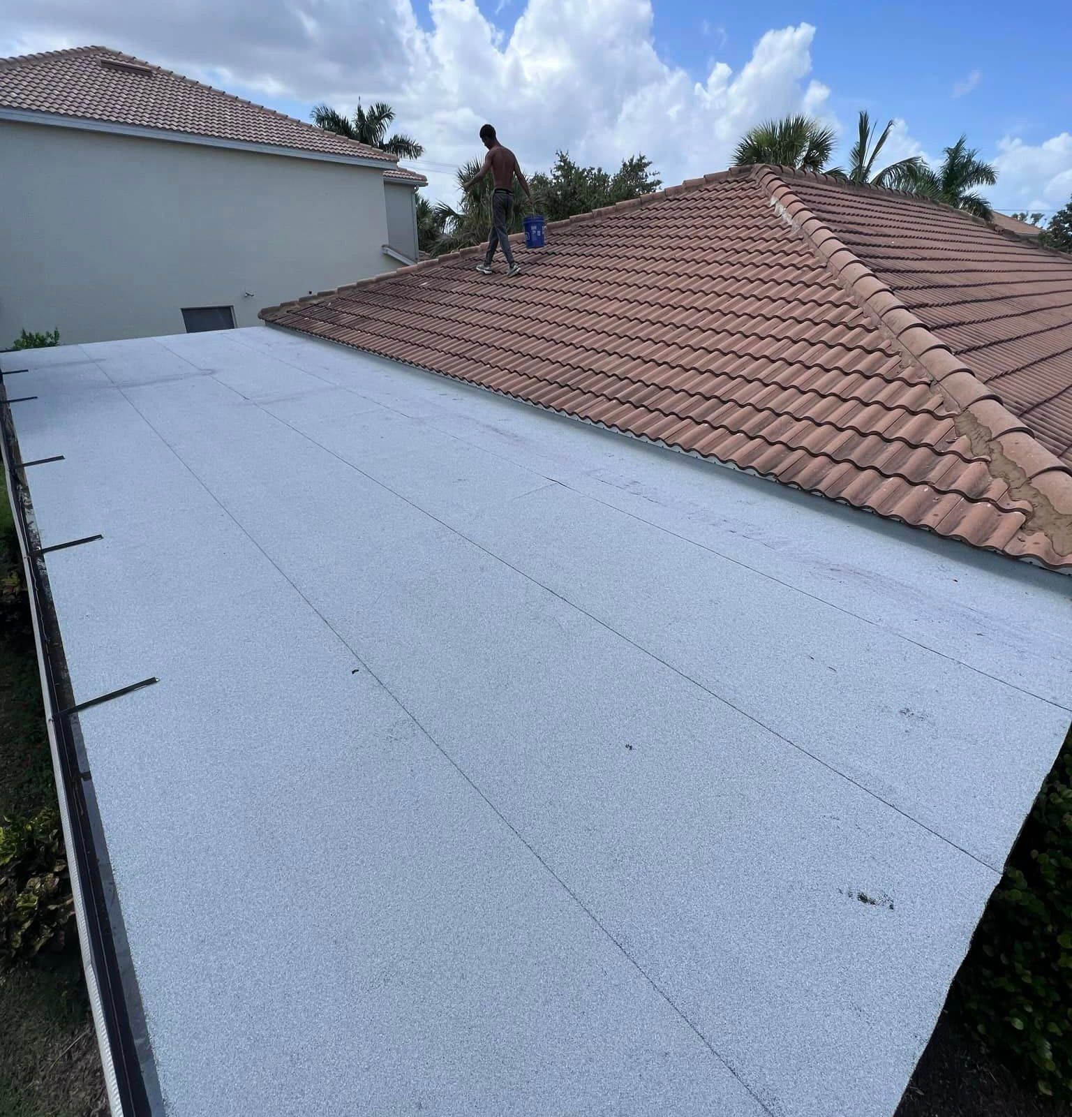 A man is standing on the roof of a house