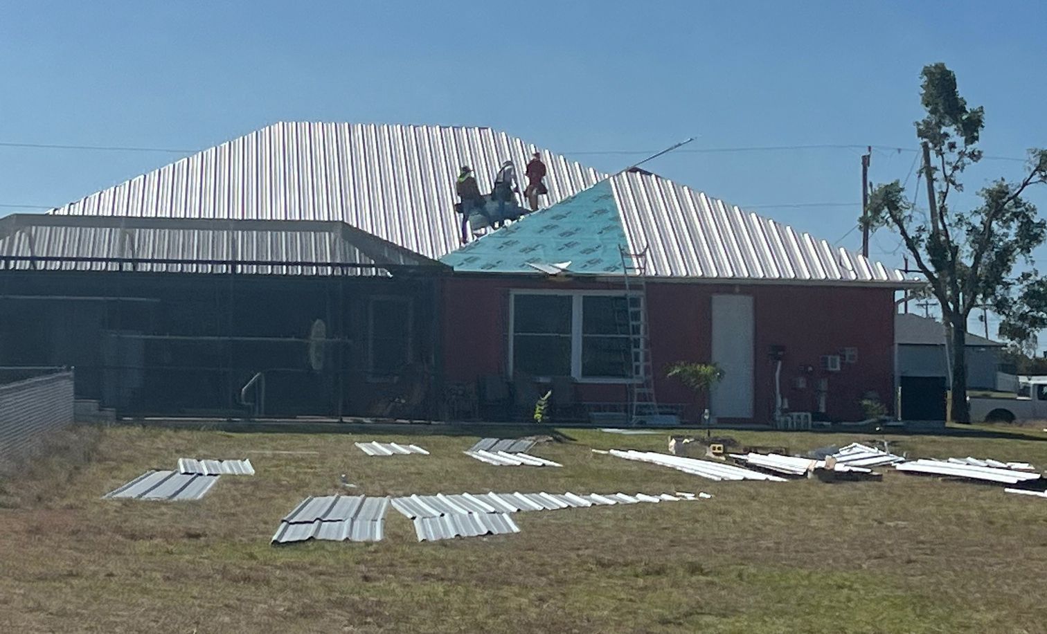 A red house with a white roof is being remodeled